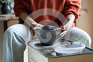 Ceramic master shaping bowl on pottery wheel in studio, creating pieces from clay