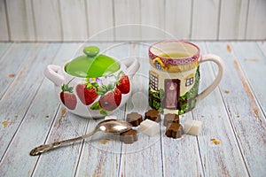 A ceramic mug with a handle depicting the windows of a wooden house, a sugar bowl with strawberries