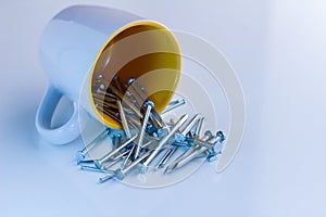 Ceramic mug with nails on white table