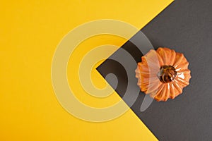 ceramic orange pumpkin on black and yellow background copy space