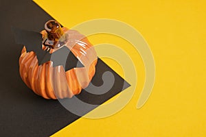 ceramic orange pumpkin on black and yellow background copy space