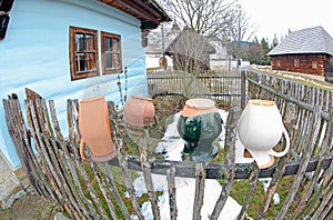 Ceramic pitcher on fence in village