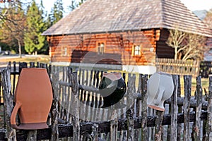 Ceramic pitcher on fence in village