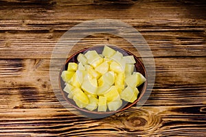 Ceramic plate with chopped canned pineapple on wooden table