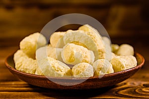 Ceramic plate with corn sticks on wooden table