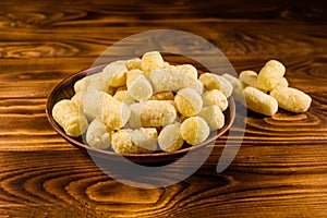 Ceramic plate with corn sticks on wooden table