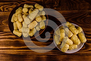 Ceramic plate with corn sticks on wooden table