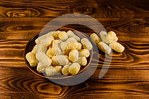 Ceramic plate with corn sticks on wooden table