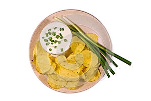 Ceramic plate with potato chips and glass bowl with sour cream i