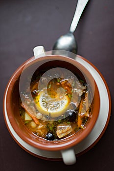 Ceramic plate with soup solyanka, russian hodgepodge soup with olives and lemon photo