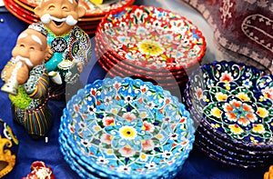 Ceramic plates and figures of Uzbek men n in traditional clothing - robe and a skullcap, painted plates