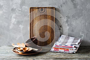 Ceramic plates, wooden or bamboo cutlery, vintage cutting board and towels in interior of kitchen