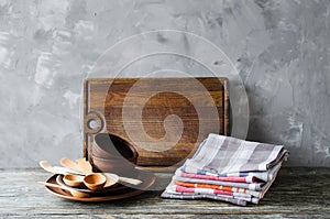 Ceramic plates, wooden or bamboo cutlery, vintage cutting board and towels in interior of kitchen