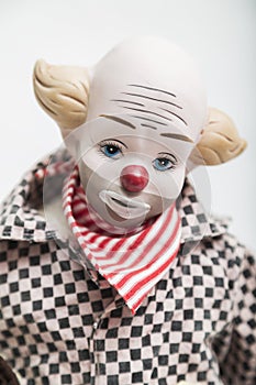 Ceramic porcelain doll of sad clown on white