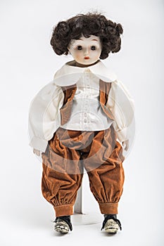 Ceramic porcelain handmade doll of a brunette boy in brown costume