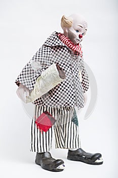 Ceramic porcelain handmade doll of sad clown on white background