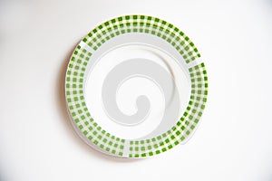 Ceramic saucer with green plaid on white backdrop