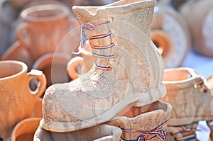 Ceramic shoes with tricolor laces for sale at a souvenir market in Romania