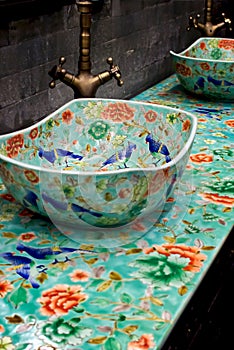 Ceramic sink with Chinese patterns. Blue birds and red flowers on a green background.