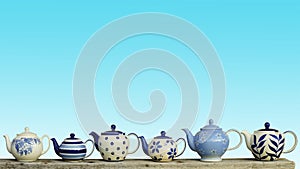 Ceramic teapot with blue pastel wall background. photo