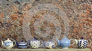 Ceramic teapot with rusty wall background.