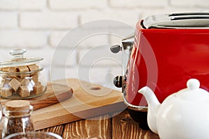 Ceramic teapot and toaster, kitchen table close up