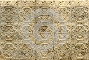 Ceramic terracotta tiles with floral and serlian motifs in relief on the socle of a Spanish house.