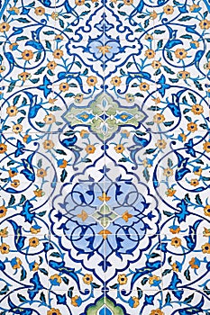 ceramic tile with a traditional Uzbek floral ornament with a pattern. Wall of white mosque Minor in Tashkent in