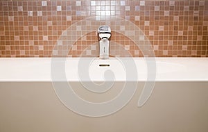 Ceramic tiles, faucet and sink in the bathroom