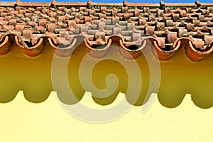 Ceramic tiles and shade on yellow house wall