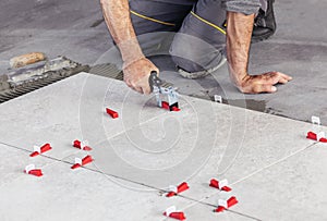 Ceramic Tiles. Tiler placing ceramic wall tile in position over