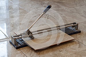 Ceramic tiles and tools for tiler. Floor tiles installation. Home improvement, renovation - ceramic tile cutting tool.