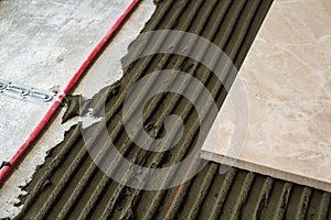 Ceramic tiles and tools for tiler. Floor tiles installation. Home improvement, renovation - ceramic tile floor adhesive,