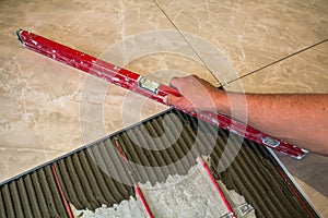 Ceramic tiles and tools for tiler. Worker hand installing floor