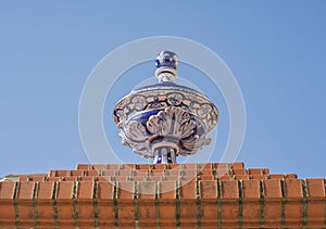 Ceramic top vase placed over brick wall