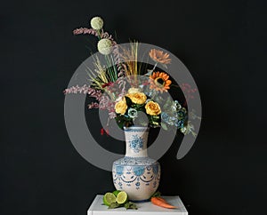 Ceramic vase with coloured flowers on a black background