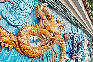 Ceramic wall decor in the form of a yellow Chinese dragon head