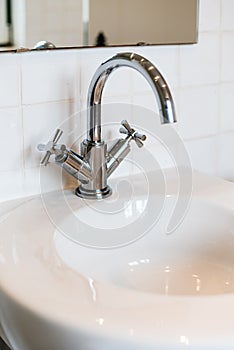 Ceramic Water tap sink with faucet with soap and towel in expensive loft bathroom or kitchen