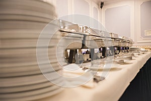 Ceramic white plates stand on top of each other on a table on the trays background