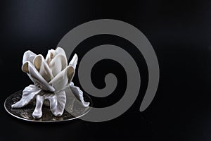 Ceramic white rose on metallic platform.