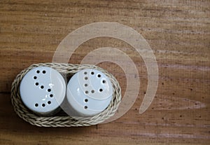Ceramic and wicker salt and pepper shakers on wooden table