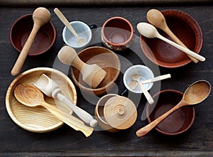 Ceramic, wooden, clay empty handmade bowl, cup and spoon on dark background. Pottery earthenware utensil, kitchenware.