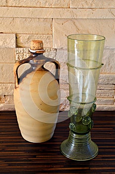 Ceramich pitcher and green wine glass photo