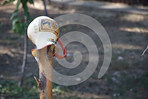 A ceramicjug with handle hanging on a fence post, selective focus