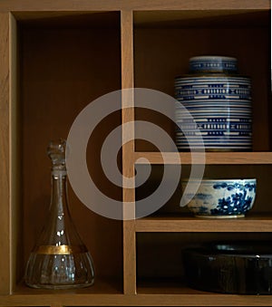 Ceramics and glass bottle decorated on wood shelf