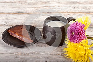 Ceramics handmade mug with milk, flowers and pie