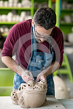 Ceramist Dressed in an Apron Sculpting Statue from Raw Clay in Bright Ceramic Workshop.