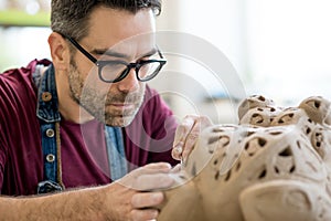 Ceramist Dressed in an Apron Sculpting Statue from Raw Clay in Bright Ceramic Workshop.