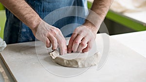 Ceramist Dressed in an Apron Working with Raw Clay in Bright Ceramic Workshop.