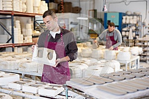 Ceramist explaining process of forming ceramic dishes in slipcasting molds photo